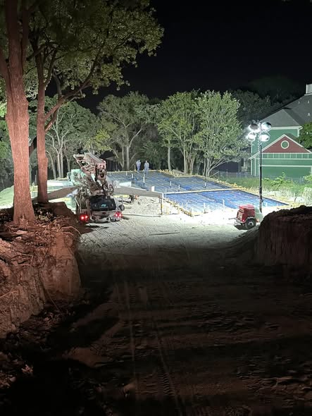 Large commercial concrete slab and court pour at night with concrete pump truck — commercial concrete work by Horseshoe Landscaping and Construction in DFW